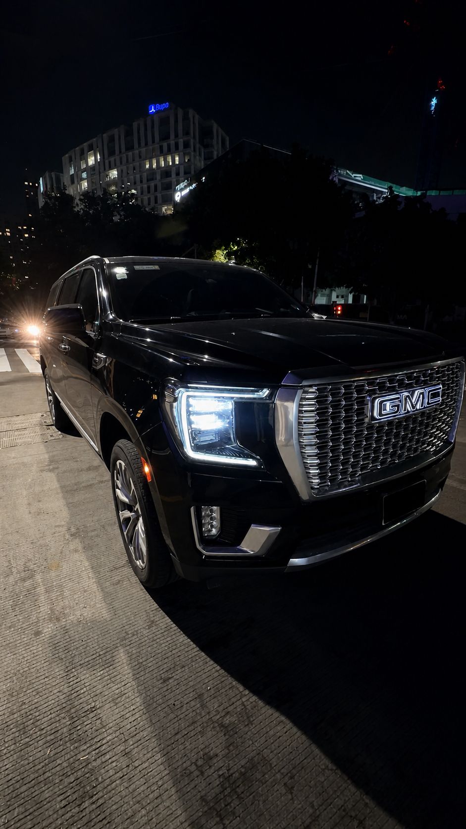 Frente de una GMC Yukon negra fotografiada de noche.